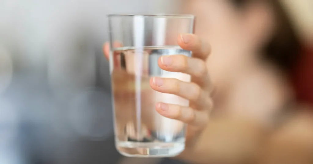 person holding a glass of clean drinkging water